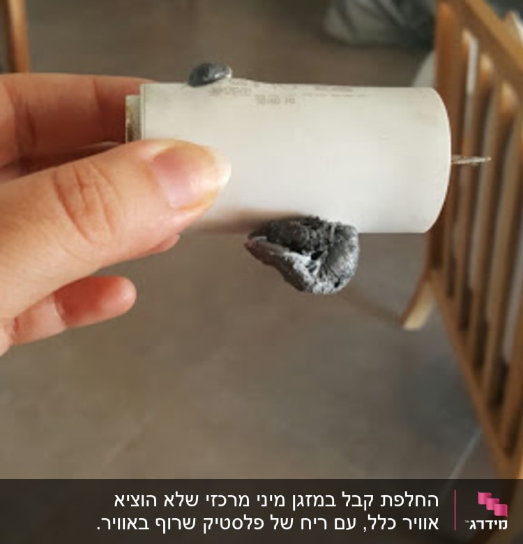יד מחזיקה רכיב של מזגן עם חוטים חשופים